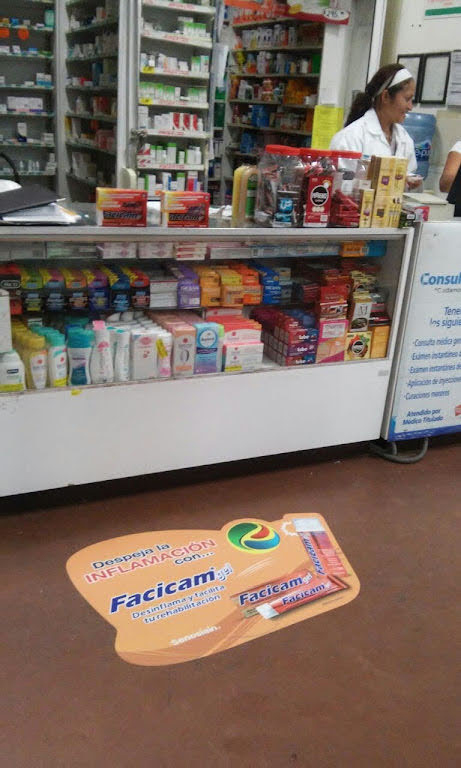 Gráfica de piso publicitaria en farmacia con vinil floor graphic y laminado antiderrapante.