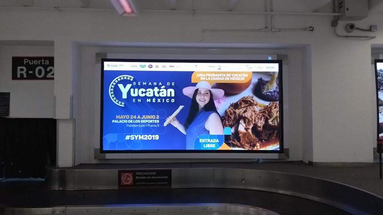 Caja de luz interior con película backlight impresa para campaña turística en aeropuerto.