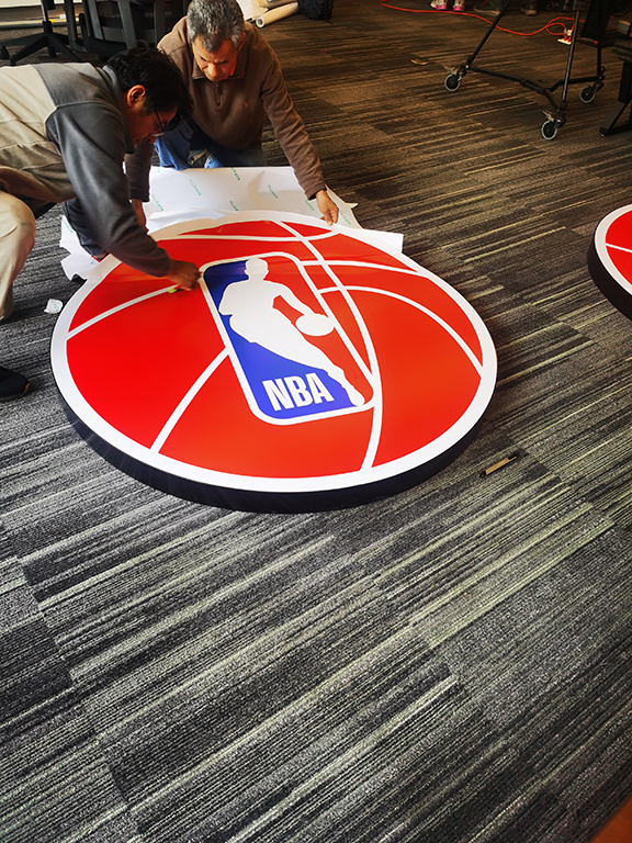 Logotipo circular impreso en vinil blanco brillante y recortado, instalación interior en CDMX.