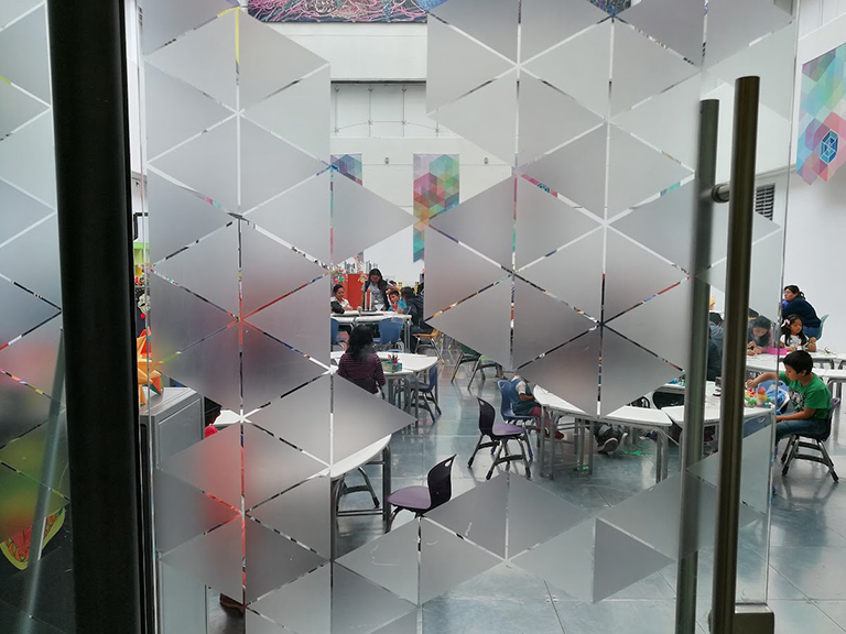 Vinil tipo esmerilado con diseño geométrico en puertas de cristal de oficina en Ciudad de México.